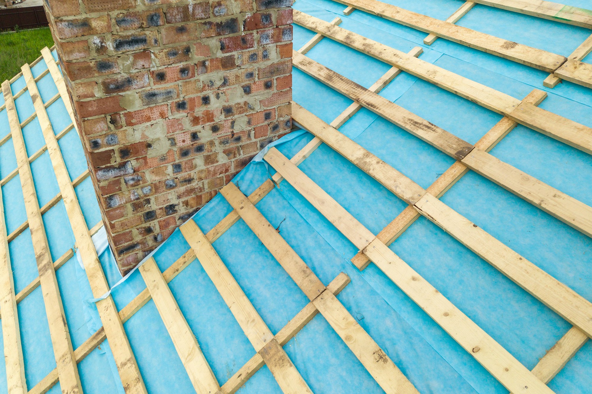 Aerial view of a wooden roof frame of brick house under construction.